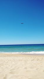 Scenic view of beach against clear blue sky