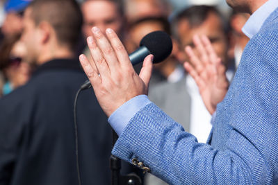 Midsection of man speaking against audience