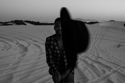 Man standing at beach against sky