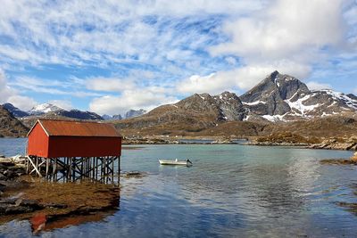 Scenic view of lake by snowcapped mountains against sky