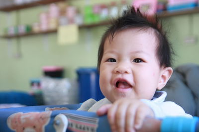 Close-up portrait of cute baby girl in crib at home