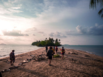 People at beach against sky