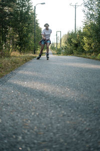 Rear view of boy riding motorcycle on road