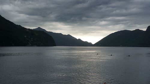 Scenic view of sea by mountains against sky