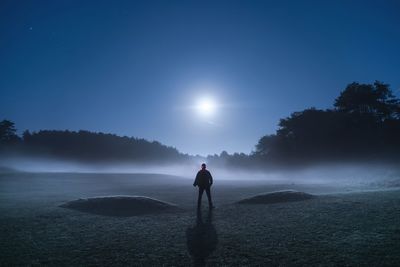 Rear view of man standing on land against sky