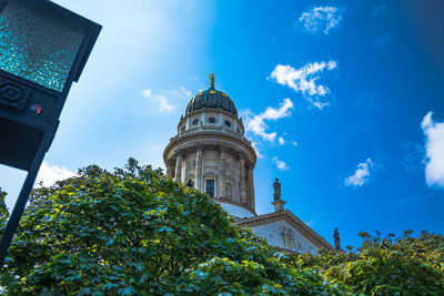 Low angle view of trees and building against sky