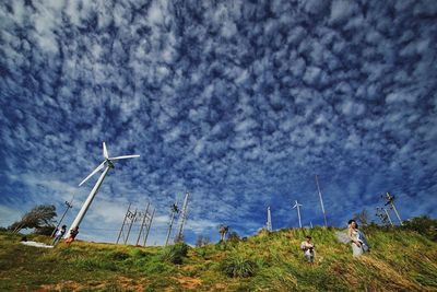 Windmills on landscape against sky