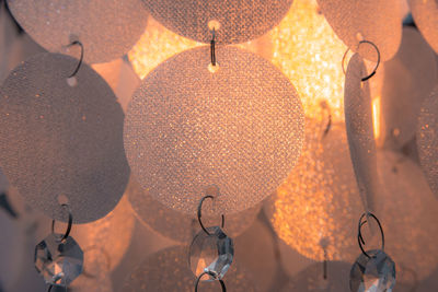 Low angle view of illuminated light bulbs hanging from ceiling