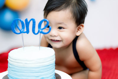 Close-up portrait of cute boy with his cake
