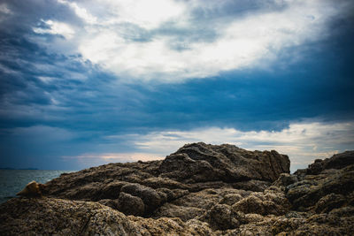 Rock formation on beach against sky