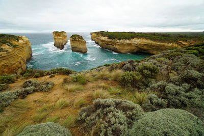 Scenic view of rocks in sea against sky along the great ocean road