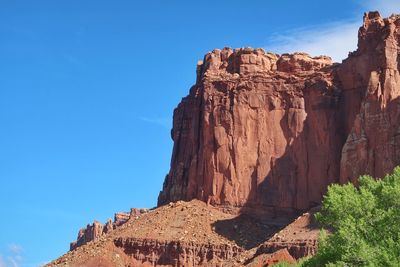 Low angle view of rock formations against blue sky