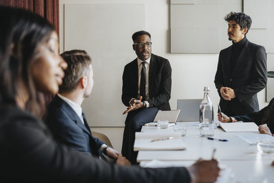 Male entrepreneur planning business strategy with colleagues during meeting at office