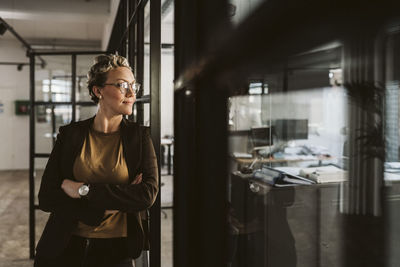 Mature businesswoman standing with arms crossed looking away