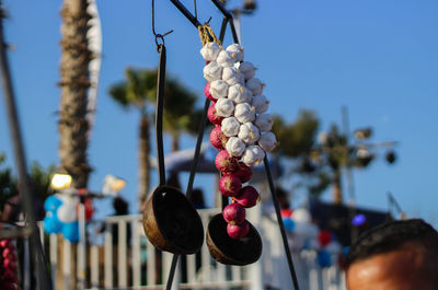 Onions and garlics with ladles hanging at market stall