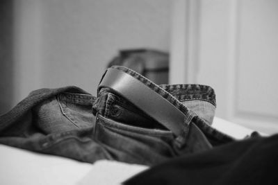 Close-up of jeans with belt on bed