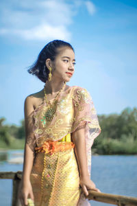 Girl in traditional clothing standing by railing