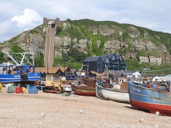 Boats moored on shore against sky