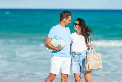 Side view of couple standing at beach