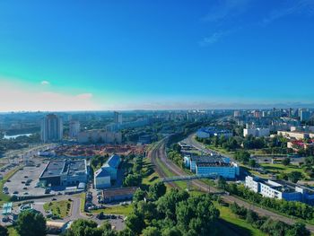 High angle view of city buildings against blue sky