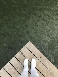Low section of man standing in lake