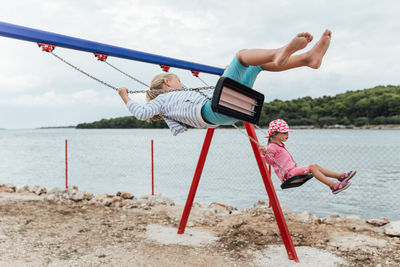 Deck chairs on beach against sky