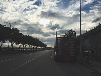 Empty road against cloudy sky