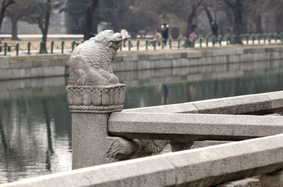 Close-up of statue on railing by river at gyeongbokgung