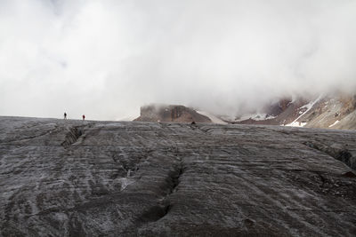 Rear view of man standing on mountain against sky