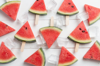 Directly above shot of watermelon slices with ice cubes on table