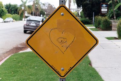 Close-up of yellow road sign in city