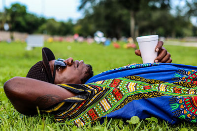 Midsection of woman holding sunglasses on field