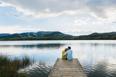 Rear view of man on lake against sky