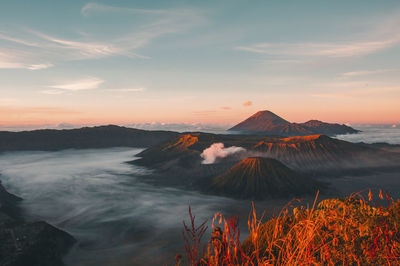 Scenic view of volcanic mountain against sky during sunset