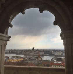 View of cityscape against cloudy sky