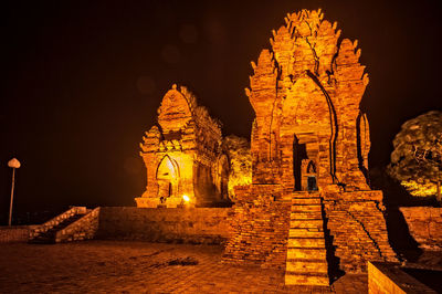 Illuminated temple against sky at night