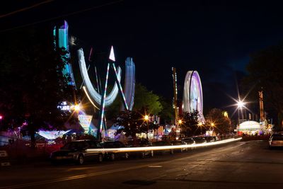 Light trails in city against sky at night