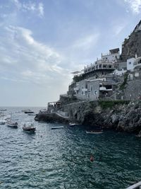 Scenic view of sea by buildings against sky