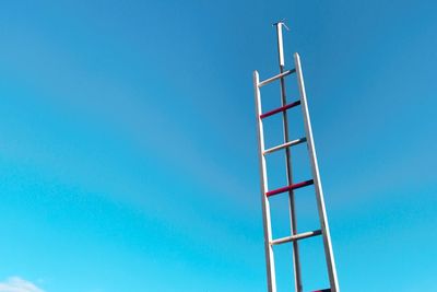 Low angle view of ladder against blue sky