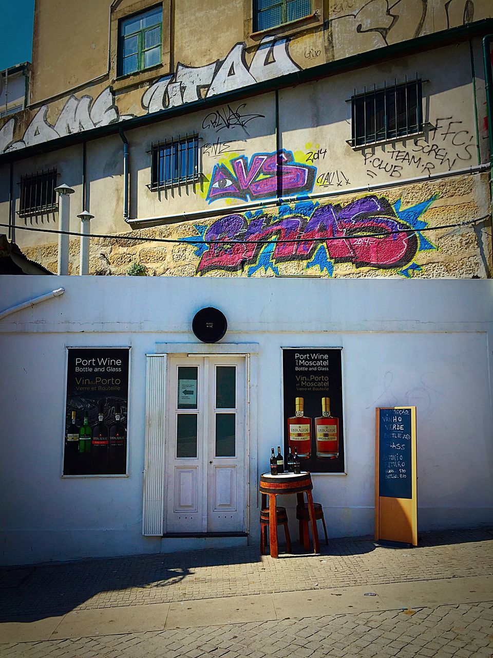 architecture, building exterior, built structure, window, residential building, house, residential structure, building, wall - building feature, multi colored, city, street, sunlight, day, blue, no people, outdoors, wall, graffiti, door