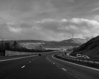 Country road against cloudy sky