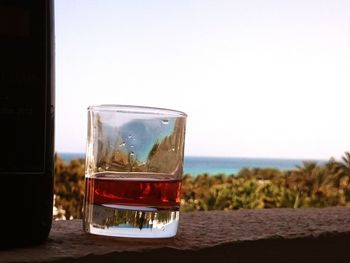 Close-up of wine in glass against sea