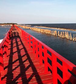 View of walkway by sea against sky