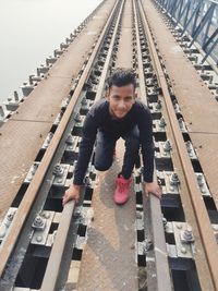 Portrait of young man standing on railroad tracks