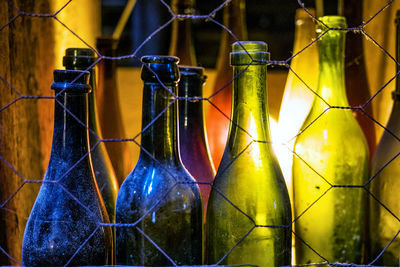 Close-up of yellow bottles on fence