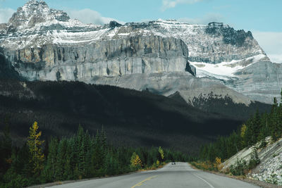 Road amidst snowcapped mountains against sky