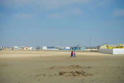 People on beach against sky