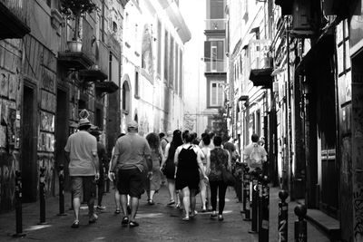 People walking on street amidst buildings in city