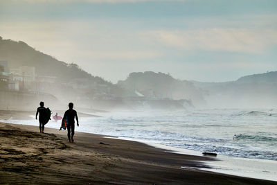 People on beach against sky
