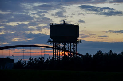 Silhouette water tower against sky at sunset